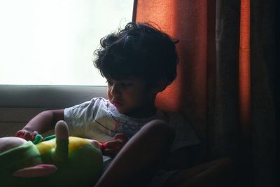 Boy looking away while sitting at home