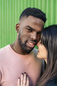 Portrait of young couple kissing outdoors