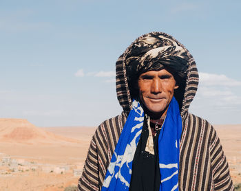 Portrait of man standing in desert against sky