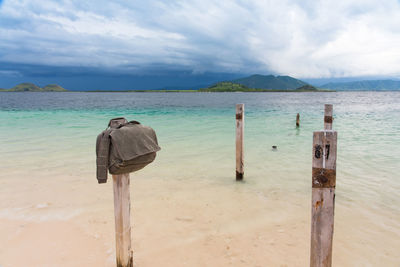 Wooden posts on beach against sky