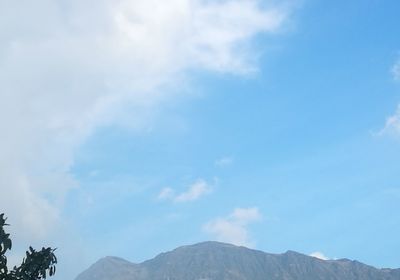 Low angle view of mountain against cloudy sky