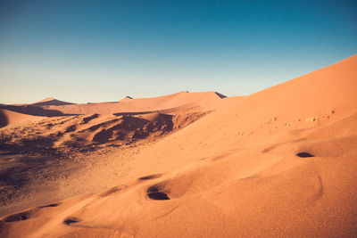 Scenic view of desert against clear blue sky