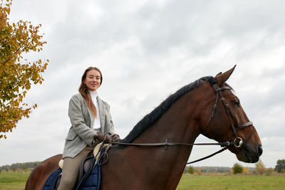 Low angle view of woman sitting on horse