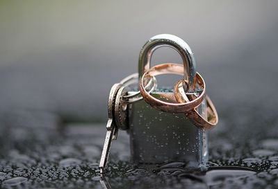 Close-up of wedding rings locked in padlock