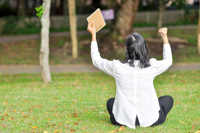 Rear view of woman standing on field