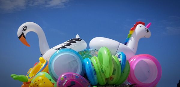 Low angle view of multi colored balloons against blue sky