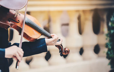 Midsection of man playing guitar at music concert