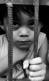 Close-up of girl behind fence