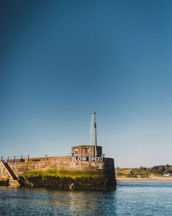 Ship in sea against clear blue sky