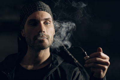 Portrait of young man smoking cigarette