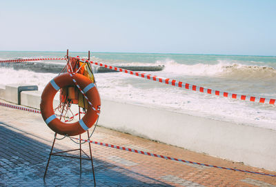 Orange lifeline on the background of a closed empty beach in a storm