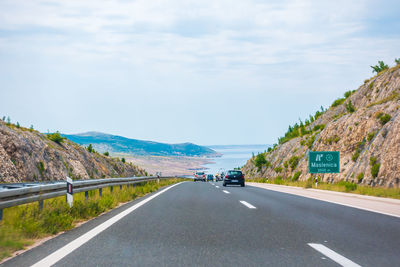 Road leading towards mountains against sky