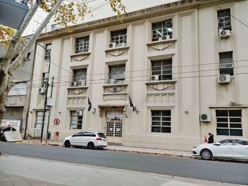 Cars on road by building in city