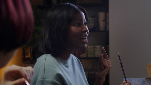 Side view of young woman looking at camera