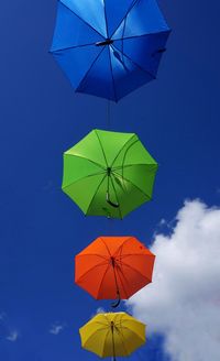 Low angle view of umbrellas hanging against sky