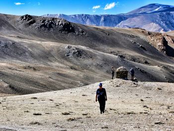 Rear view of men walking on mountain