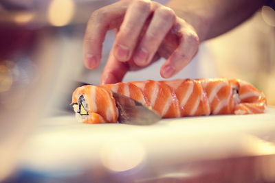 Cropped image of chef cutting sushi in restaurant