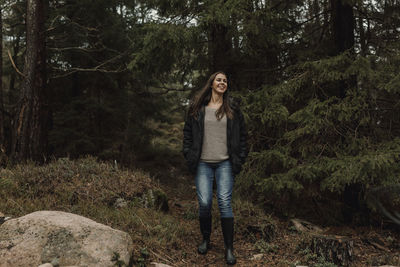 Portrait of young woman standing in forest