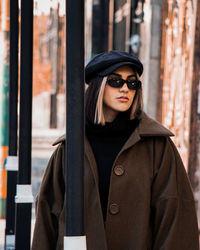 Portrait of young woman standing in city