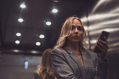 Portrait of young woman standing in city at night