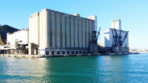 Commercial dock in city against clear sky