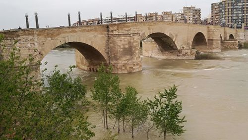 Arch bridge over river against sky