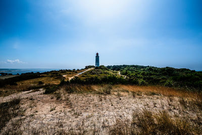 Lighthouse by sea against sky