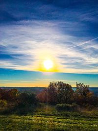 Scenic view of field against sky at sunset