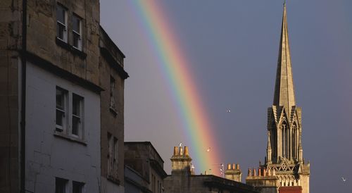 Low angle view of rainbow over buildings in city