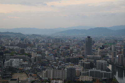 Aerial view of buildings in city against sky