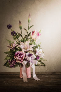 Close-up of pink flower vase on table against wall