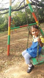 Cute girl playing on swing in playground