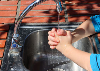 Low section of man washing hands