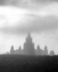 Skyscrapers in city against cloudy sky