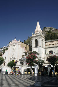 View of church and building against clear blue sky