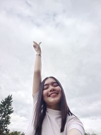 Low angle view of woman standing against sky