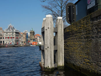 Canal amidst buildings against clear sky