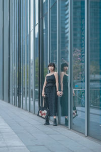 Side view of young woman standing in city