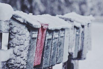 Close-up of snowed mailboxes in a row