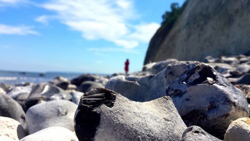 Close-up of pebbles on beach against sky