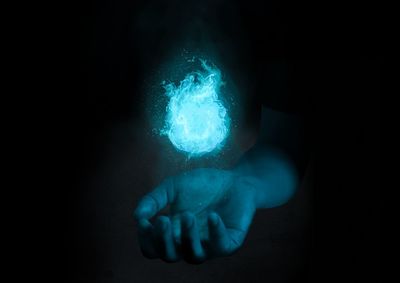 Digital composite image of hand holding illuminated light 