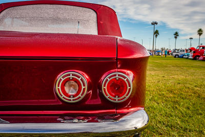 Close-up of red vintage car on field