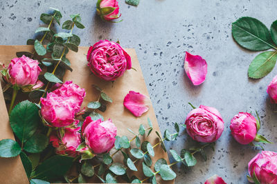 Directly above shot of pink roses in envelope on table