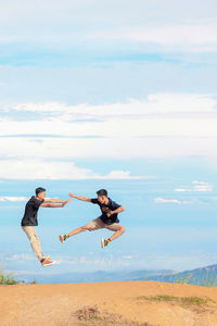 People on land by sea against sky