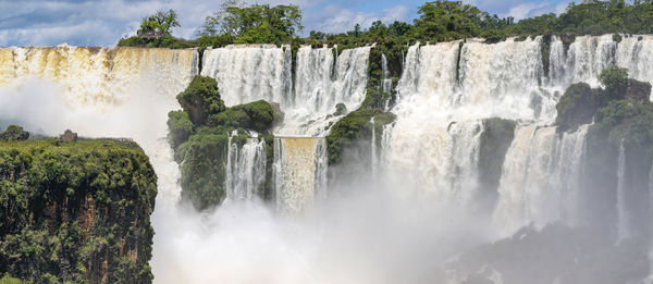 Scenic view of waterfall against sky