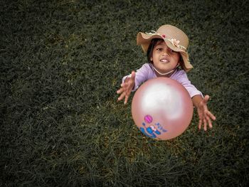 Playing child. pink ball with green grass background. 