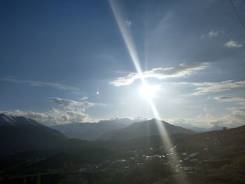 Sunlight streaming through mountains against bright sun