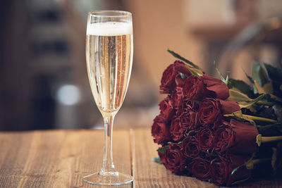 Close-up of red rose on glass table