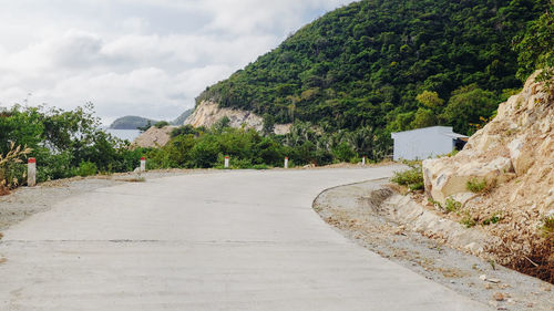 Road by mountain against sky