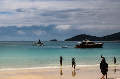 People on beach against sky